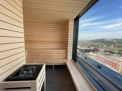 a sauna with a large window in a building at Luxe studio with pool, sauna, jacuzzi, gym, balcony in Prague