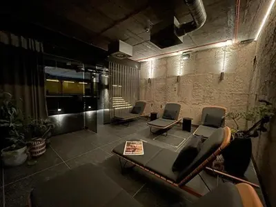 a room with two chairs and a table in a building at Luxe studio with pool, sauna, jacuzzi, gym, balcony in Prague