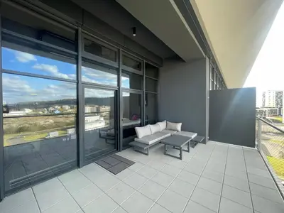 a balcony with a couch and a table on a building at Luxe studio with pool, sauna, jacuzzi, gym, balcony in Prague
