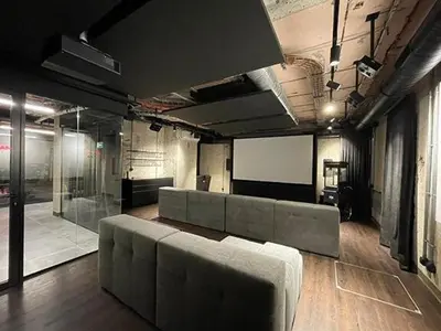 a large room with a couch and a screen at Luxe studio with pool, sauna, jacuzzi, gym, balcony in Prague