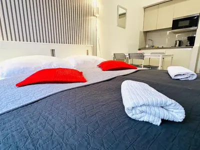 a large bed with red and white pillows on it at Elly Modern Oldtown Apartments in Prague