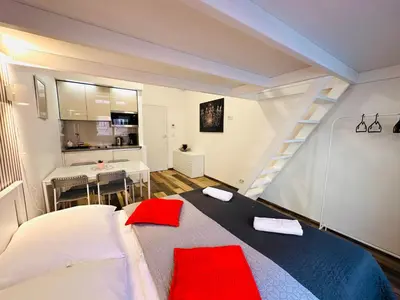 a room with a bed and a kitchen and a staircase at Elly Modern Oldtown Apartments in Prague