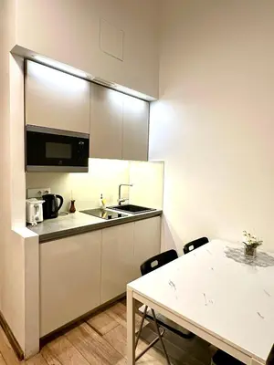 a kitchen with a sink and a table with chairs at Elly Modern Oldtown Apartments in Prague