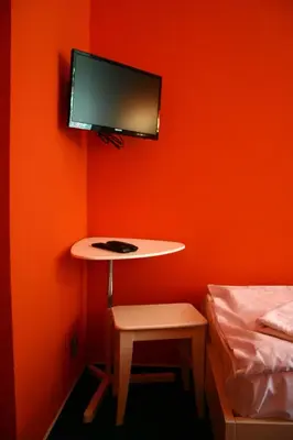 a room with a table and a bed and a tv at Hotelové Pokoje Kolčavka in Prague