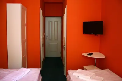a room with two beds and a tv on the wall at Hotelové Pokoje Kolčavka in Prague