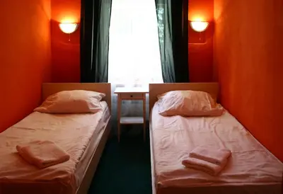 two beds in a small room with towels on them at Hotelové Pokoje Kolčavka in Prague