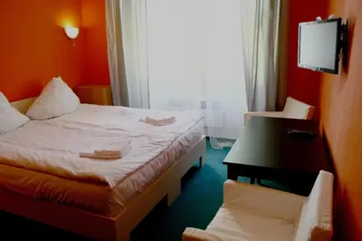 a room with a bed and a desk and a window at Hotelové Pokoje Kolčavka in Prague