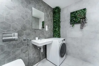 a bathroom with a sink and a washing machine at Rentero One bedroom O2 Arena Dinopark Apartment in Prague