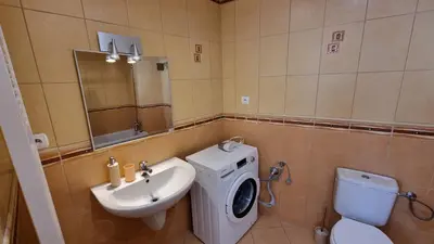 a bathroom with a toilet sink and a washing machine at Opatovicka affordable stay in Prague