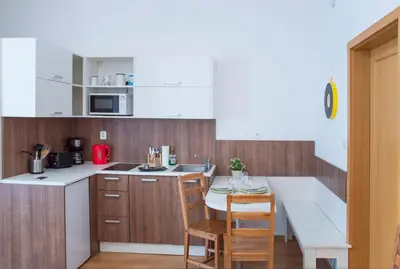 a kitchen with white counters and a table and chairs at Opatovicka affordable stay in Prague