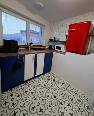 a small kitchen with a counter and two windows at Bnest in Beroun