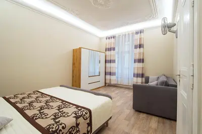 a small bedroom with a bed and a couch at Navratilova Apartment in Prague