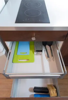 a drawer in a desk with a book and utensils at Navratilova Apartment in Prague