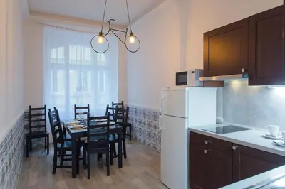 a kitchen with a table with chairs and a refrigerator at Navratilova Apartment in Prague