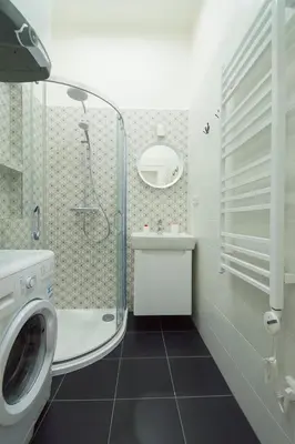 a bathroom with a shower and a washing machine at Navratilova Apartment in Prague