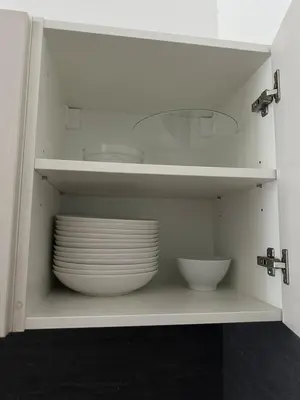 a white cabinet with plates and bowls in it at Chic Retreat on Skorepka Street in Prague