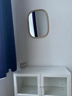 a mirror on a wall above a white cabinet at Chic Retreat on Skorepka Street in Prague
