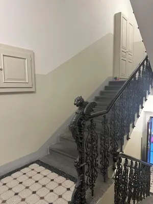 a staircase with a black wrought iron railing at Chic Retreat on Skorepka Street in Prague