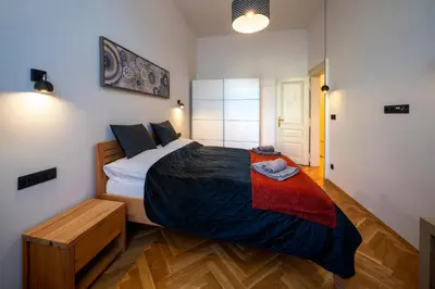 a bedroom with a large bed with a wooden floor at OLD TOWN - 3 Room 2 Bathroom Balcony in Prague