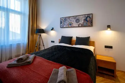 a bedroom with a bed with a red blanket at OLD TOWN - 3 Room 2 Bathroom Balcony in Prague