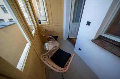 a balcony with two chairs and a table and windows at OLD TOWN - 3 Room 2 Bathroom Balcony in Prague