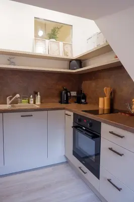 a kitchen with white cabinets and an oven at Malebný byt pod hradem Křivoklát in Křivoklát