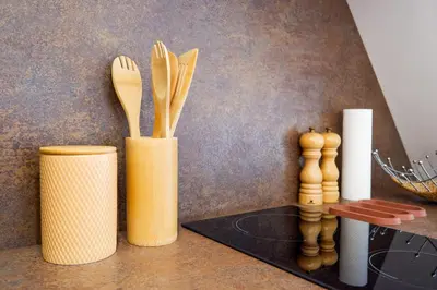 a vase filled with wooden utensils on a counter at Malebný byt pod hradem Křivoklát in Křivoklát