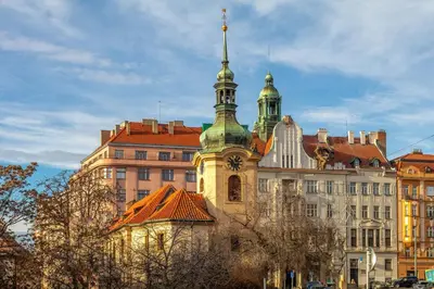 a building with a clock tower on top of it at Sunny luxury apartments Grebovka in Prague
