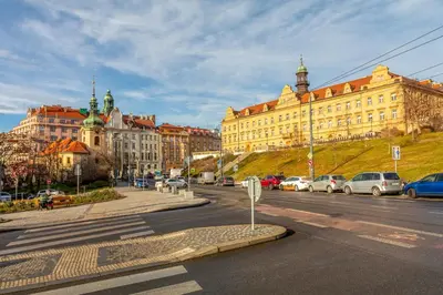 a city street with buildings and cars parked on the road at Sunny luxury apartments Grebovka in Prague