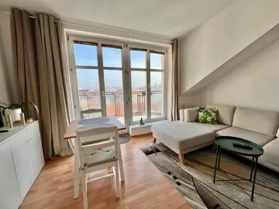 a living room with a couch and a large window at Cozy Studio with Prague panorama view in Prague