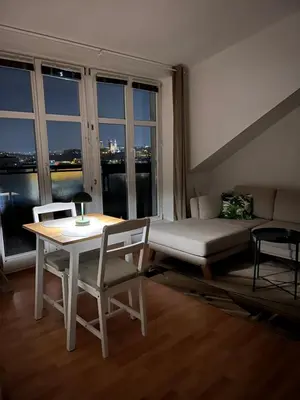 a living room with a table and chairs and a couch at Cozy Studio with Prague panorama view in Prague
