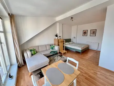 a living room with a couch and a table at Cozy Studio with Prague panorama view in Prague