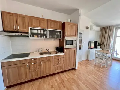 a kitchen with wooden cabinets and a wooden floor at Cozy Studio with Prague panorama view in Prague