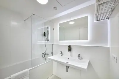 a white bathroom with a sink and a mirror at DownTown Suites Andel in Prague