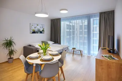 a living room with a table and chairs and a couch at DownTown Suites Andel in Prague