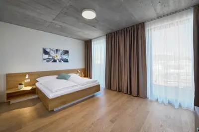 a bedroom with a bed and a large window at DownTown Suites Andel in Prague