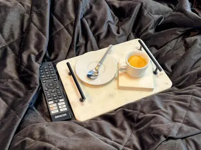 a tray with a cup of coffee and a remote control at Cinematic Apartment with Pool Table & Cinema room in the heart of Prague in Prague