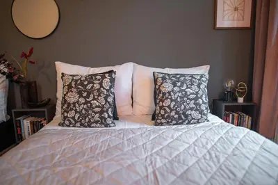 a bed with two pillows on top of it at Cinematic Apartment with Pool Table & Cinema room in the heart of Prague in Prague