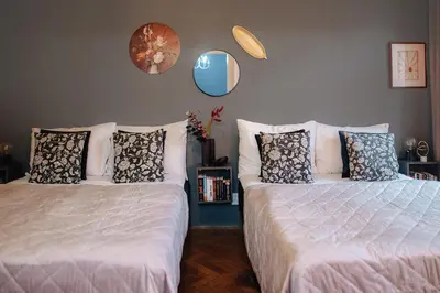 two beds sitting next to each other in a bedroom at Cinematic Apartment with Pool Table & Cinema room in the heart of Prague in Prague