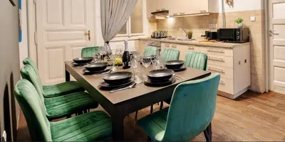 a kitchen with a table and chairs with dishes on it at Cinematic Apartment with Pool Table & Cinema room in the heart of Prague in Prague