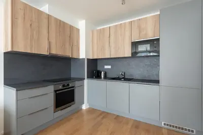 a kitchen with white cabinets and a sink at Fresh All-in Apartment Prague in Prague