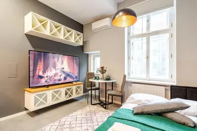 a bedroom with a flat screen tv on a wall at Place of Grace - A Few Steps From the Museum in Prague