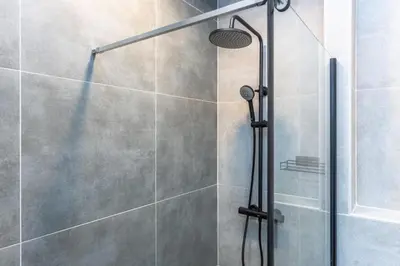 a shower with a glass door in a bathroom at Place of Grace - A Few Steps From the Museum in Prague