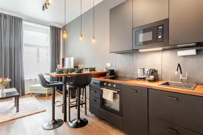 a kitchen with a counter and a table with chairs at Place of Grace - A Few Steps From the Museum in Prague