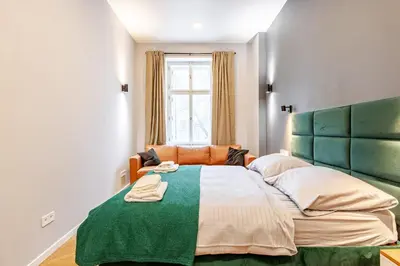 a bedroom with a large bed with a green headboard at Place of Grace - A Few Steps From the Museum in Prague