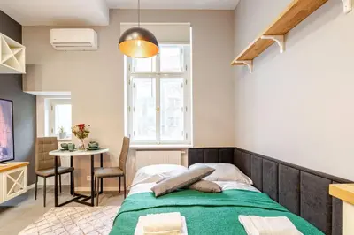 a bedroom with a bed and a table and a window at Place of Grace - A Few Steps From the Museum in Prague