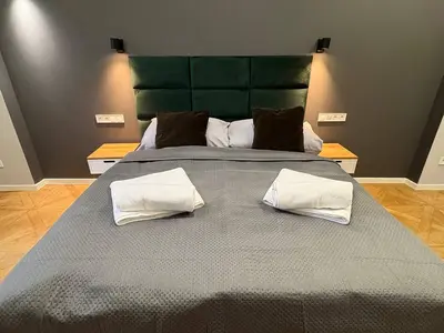 a large bed with a green headboard and white pillows at Place of Grace - A Few Steps From the Museum in Prague