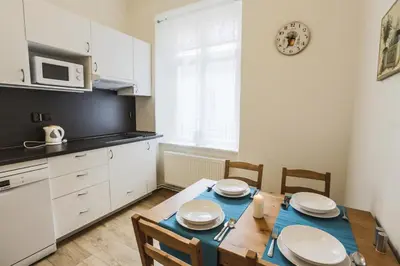 a kitchen with a table and chairs and a kitchen with white cabinets at Accommodation Smečky 14 in Prague