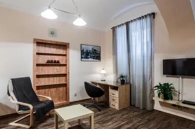 a living room with a chair a desk and a tv at Accommodation Smečky 14 in Prague