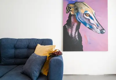 a painting of a dog on a wall next to a couch at The Grand Krocínova Loft - Golden Bond Retreat in Prague